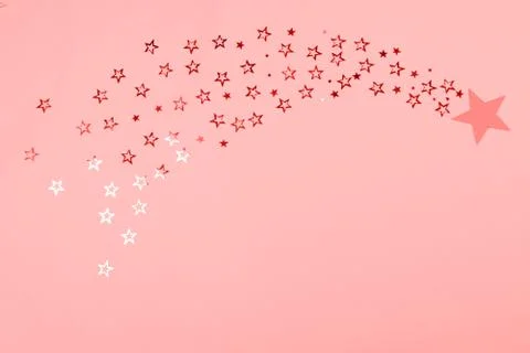 Falling star of star-shaped confetti toned in coral. Stock Photos