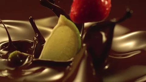 Falling strawberry and lemon on the liquid chocolate in slow motion Stock Footage 256939624