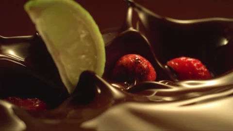 Falling strawberry and lemon on the liquid chocolate in slow motion Stock Footage 256939756