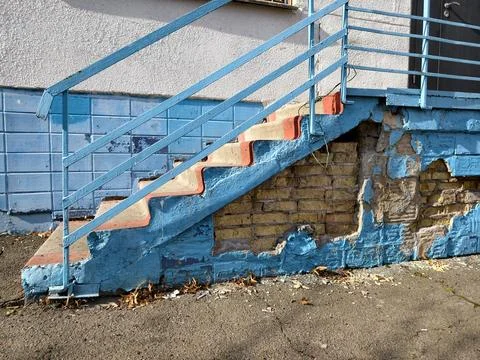 Falling tiles and broken steps on the school facade, showing signs of wear .. Foto stock