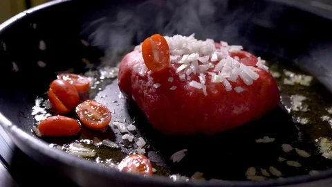 Falling vegetables on ham meat steak grill on a pan onion and tomato Stock Footage 94264123