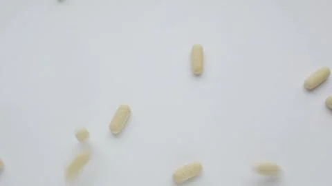 Falling vitamin pills Stock Footage 169627152