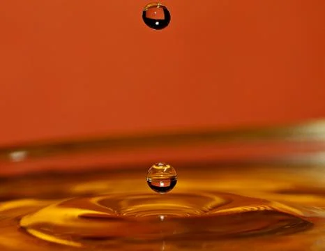 Falling water drop and water surface Stock Photos