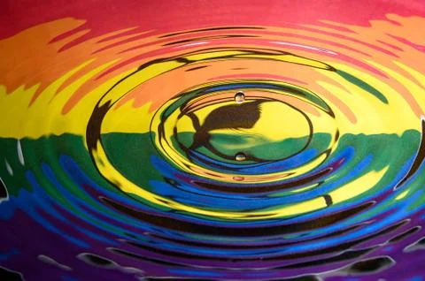 A falling water drop reflected in the circular waves from a splash Stock Photos