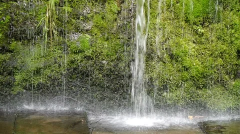 Falling water drops off ledge onto stones Stock Footage 41696595