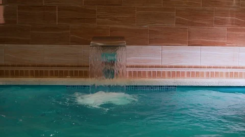 Falling water in the pool in the Spa hotel resort, waterfall in the pool slow mo Stock Footage 114326294