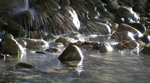 Falling water sprays into the sunlight stream (High Definition) Video stock 69227