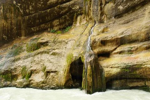 Falling waterfall with a grotto and a river in the Chegem gorge Stock Photos