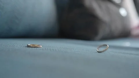 Falling wedding rings on a sofa. Stock Footage 322900207