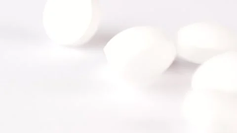 Falling white round pills on white background, macro shot. Video stock 301712538