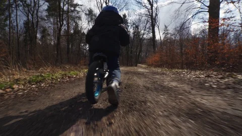 Fallow cam of a kid riding push bike Stock Footage 121038711