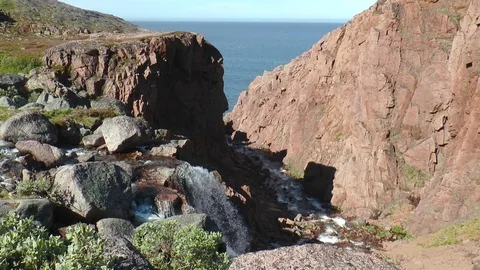 Falls among the rocks on the background of bright blue sea. Video stock 71020342