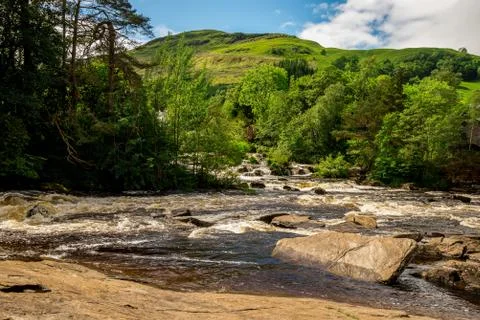 Falls of Dochart and mountain background landscape at town of Killin Stock Photos