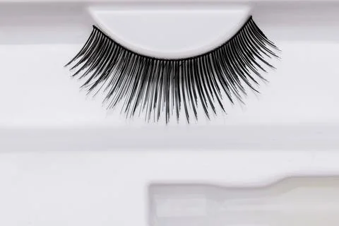 False eyelashes in a box with a glue on white background. Cosmetic products.. Stock Photos