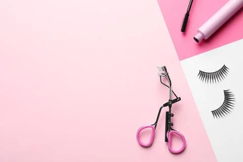 False eyelashes, curler and mascara on color background, flat lay. Space for  Stock Photos