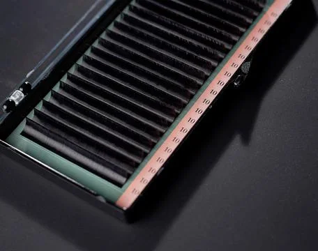 False eyelashes for extension in a box, used for eye makeup on a black backgr Stock Photos