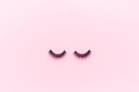 False eyelashes lying on pink background. Beauty and makeup concept. Flatlay Foto stock