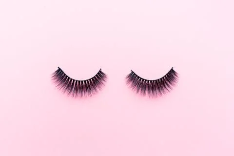 False eyelashes lying on pink background. Beauty and makeup concept. Flatlay, Stock Photos