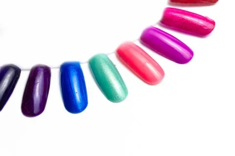 False multi-colored nails on a sampler on a white background. close up Stock Photos