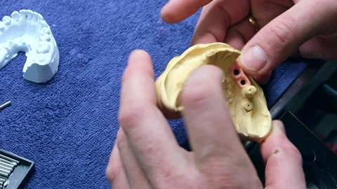 False teeth. Professional Technician Using Tool To Cut Artificial Dental Model Stock Footage 232970732