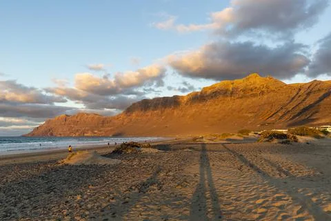 Famara beach and Risco de Famara mountains at sunset, Spain Stock Photos