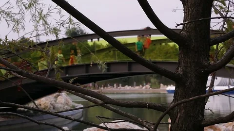 Families Crossing Pond Bridge Stock Footage