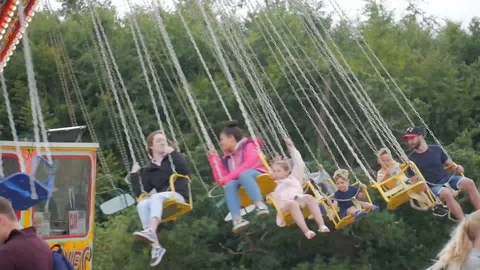 Families Having Fun On Fairground Ride Stock Footage