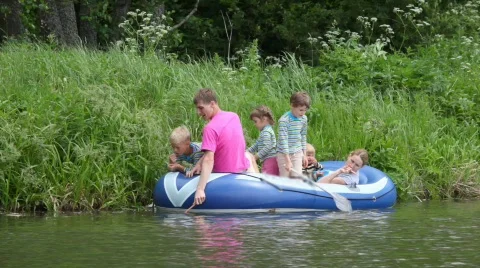 Family with 4 kids in rubber boat, fishing Stock Footage