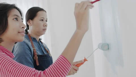 Family Asian with mother and  daughter painting house wall interior together Stock Footage
