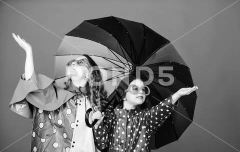 Family bonds. Small girls in raincoat. happy small girls with colorful umbrella Stock Photos
