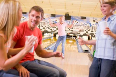 Family in bowling alley cheering and smiling Stock Photos