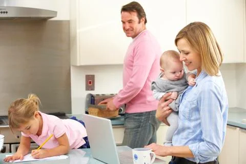 Family busy together in kitchen Stock Photos