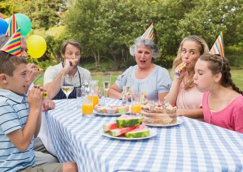Family celebrating little girls birthday outside at picnic table Stock Photos