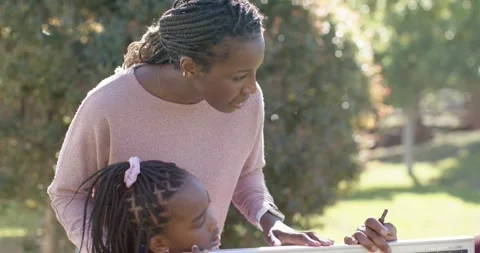 Family checking PV panel in yard, woman leaning over child urging man fixing Stock Footage 346725714