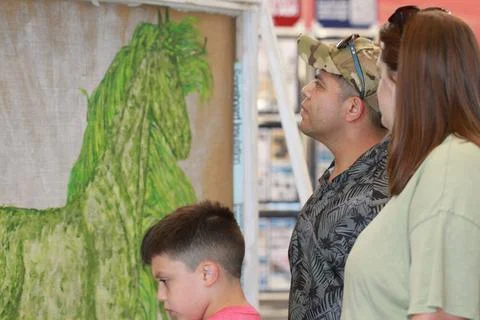 A family checks out the Joint Operation Mariposas painting that was on di.. Stock Photos