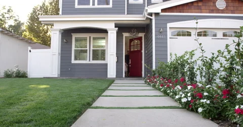 Family Coming Out Of Front Door Of Suburban Home Shot On R3D Stock Footage