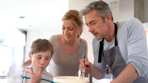 Family cooking together in modern home kitchen Stock Footage
