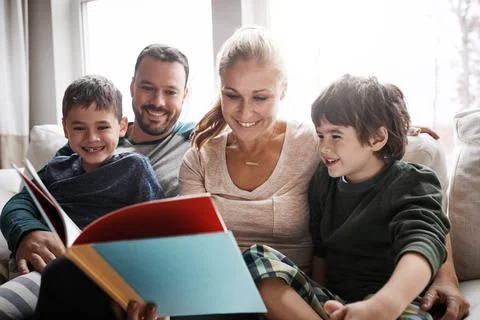 Family, couple and children on sofa for storytelling time with books and Stock Photos
