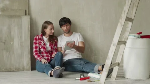 Family couple using digital tablet during renovation in new house. Young couple Stock Footage 153840981