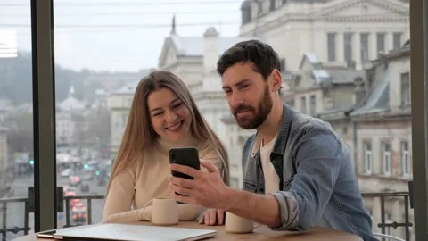 Family couples talking video using mobile phone from cafe panoramic view window. Stock-Footage 145483353