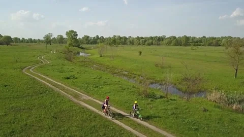 Family cycling on bikes outdoors aerial view from above Stock Footage