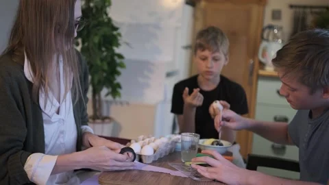 Family decorating Easter eggs together, mother and sons crafting festive Stock-Footage 336669045