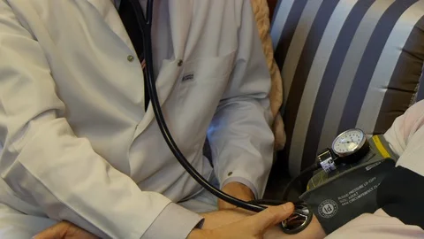 Family doctor measures patient's blood pressure. Stock Footage