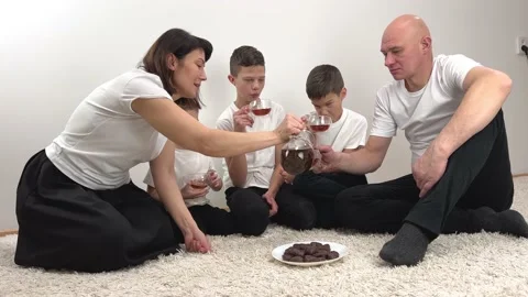 Family drink tea in the evening at the same time, simultaneously bring glasses Video stock 233424681