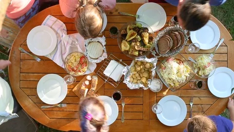 The family eats sitting at the table top view. Friends have dinner.  Vídeo Stock 111906975