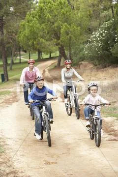 Family enjoying bike ride in park Stock Photos