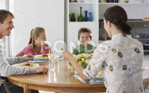 Family Enjoying Meal At Dining Table Stock Photos