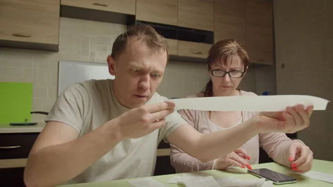 Family in the evening sitting at the table checking expenses on checks, family Stock Footage 149147048