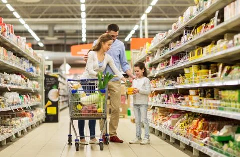 Family with food in shopping cart at grocery store Stock Photos