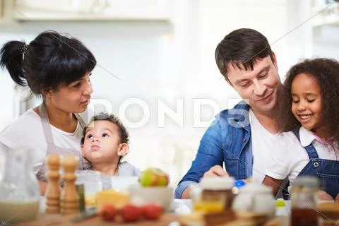 Family of four having breakfast in the kitchen Stock Photos